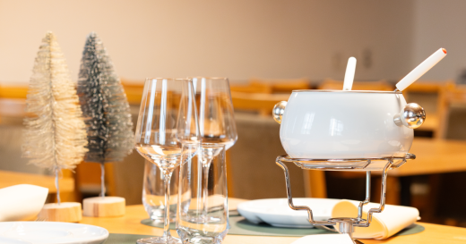 Gedeckter Tisch mit Gläsern, Besteck und Fondue Chinoise Pfanne